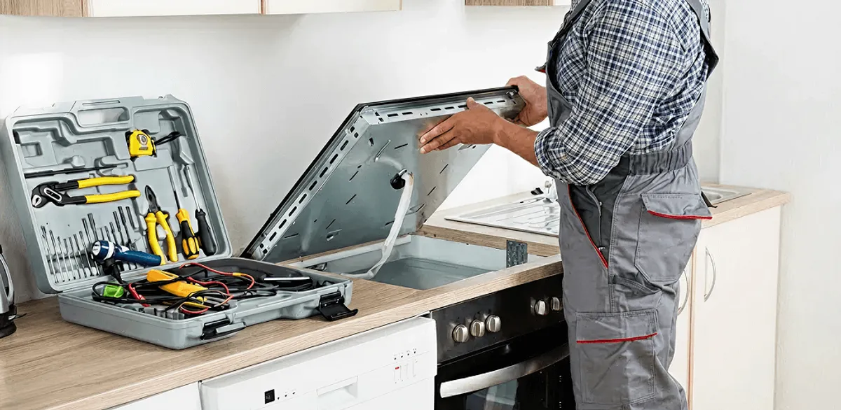 Handyman repairing a cooktop and checking wiring connections in Cambridge, MA