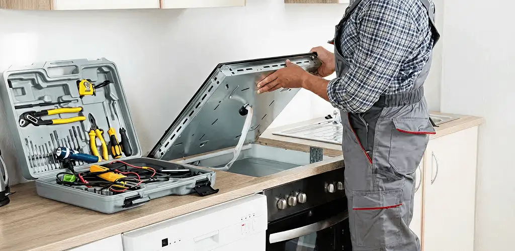 Handyman repairing a cooktop and checking wiring connections in Cambridge, MA