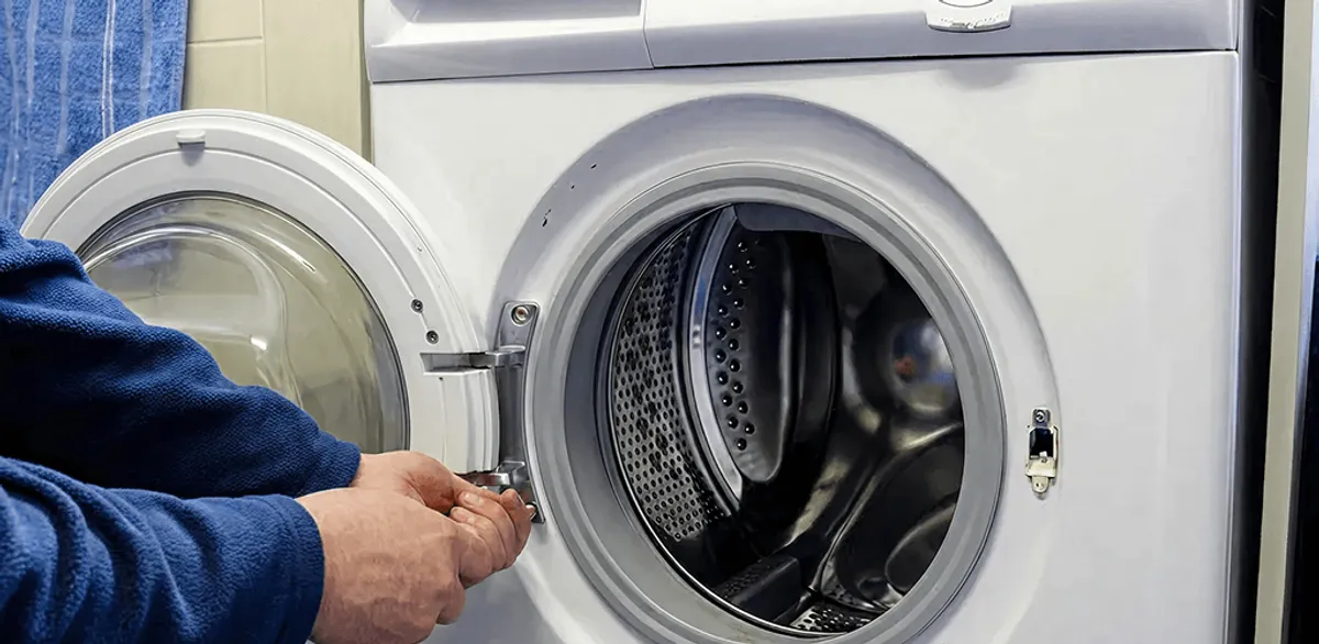 Washing machine repair handyman checking a front-load washer door and latch in Cambridge, MA