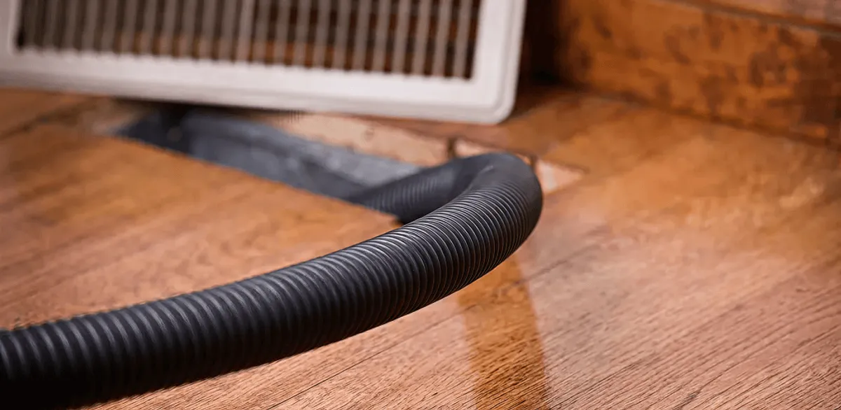 Air duct cleaning hose inserted into a floor vent for ductwork cleaning in Cambridge, MA